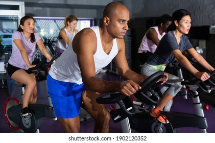 Man ride stationary bike in a fitness club - Powered by Shutterstock