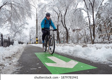 A man rides a bike in the winter along the bike path. Eco-friendly mode of urban transport - Powered by Shutterstock