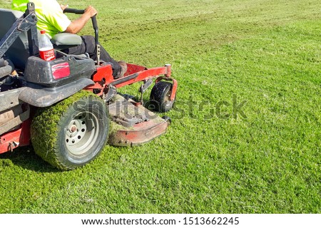 A man rides a lawn mower. Lawn Care. Riding Mower. Grass