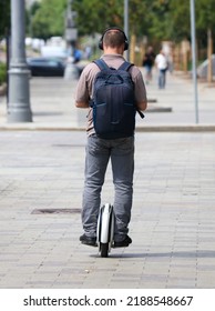 A Man Rides A Unicycle Electric Bike In The City.