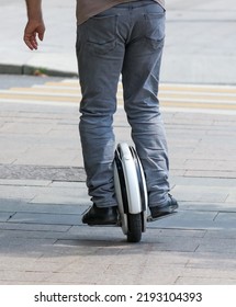 A Man Rides A Unicycle Electric Bike In The City.