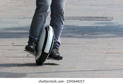 A Man Rides A Unicycle Electric Bike In The City.