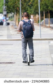 A Man Rides A Unicycle Electric Bike In The City.