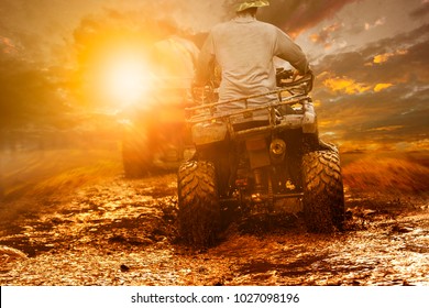 Man Riding Atv Through Mud Terrain Field 