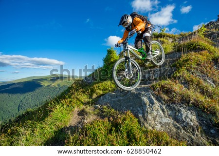 A man is riding bicycle, on the background of mountains and blue sky. Beautiful summer day. Mountain bike race