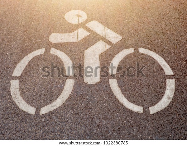 Man riding bicycle\
sign in the bike lane.