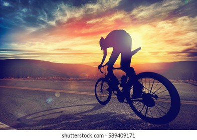 Man riding a bike in high mountains at sunset. Extreme sport, speed, risk, lifestyle.