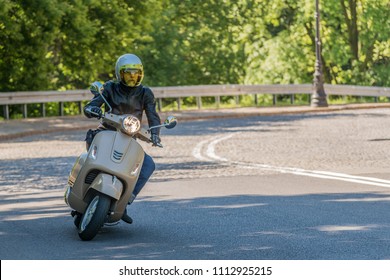Man riding classic scooter
