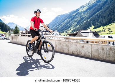 Man Riding E Bike Bicycle In City. Electric Bike In Summer