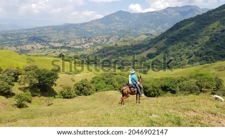 Man riding horse with natural landscape view. Tamesis, Antioquia, Colombia.