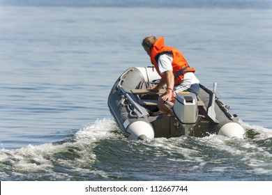 Man Riding In An Inflatable Boat With A Motor On Sea