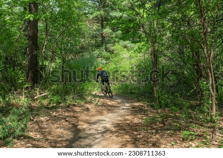 Man riding mountain bike through forest making a sharp turn