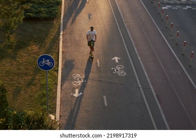 Man Is Riding On Kick Scooter On Cycling Road. Top Aerial View.