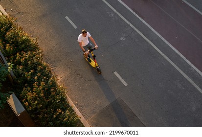 Man Is Riding On Kick Scooter On Cycling Road. Top Aerial View.