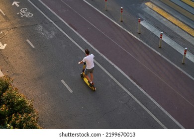 Man Is Riding On Kick Scooter On Cycling Road. Top Aerial View.