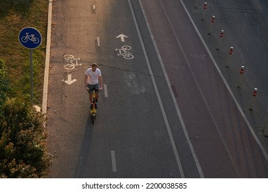 Man Is Riding On Kick Scooter On Cycling Road. Top Aerial View.