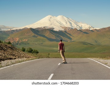 Man Riding on skateboard on Road to Elbrus, Highest Mount in Europe. - Powered by Shutterstock