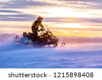 A man is riding snowmobile in mountains. Beautiful morning light. Blue shadows.