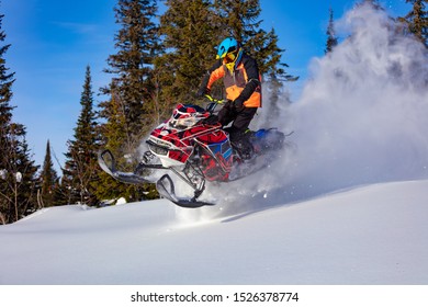 A Man Is Riding Snowmobile In Mountains. Beautiful Morning Light. Jump On A Snow Bike.
Pilot On A Sports Snowmobile In A Mountain Forest. The Concept Of Skidooking. Lifestyle Is Active In Winter Sport