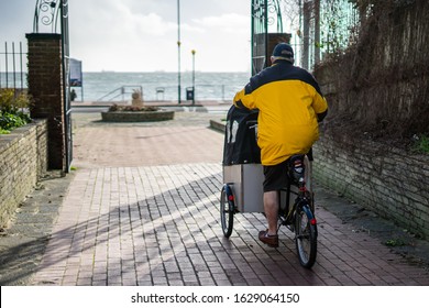 A Man Riding A Three Wheeled Bike Or Tricycle With A Baby Carrier On The Front