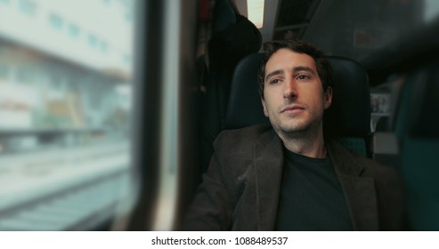 Man Riding Train Looking Out Window