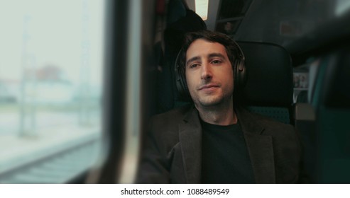 Man Riding Train Looking Out Window