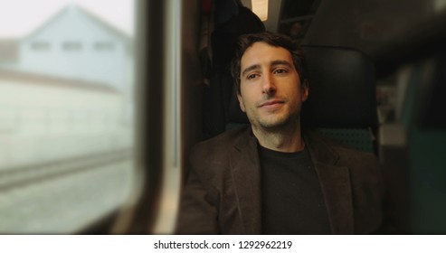 Man Riding Train Looking Out Window