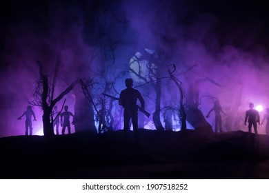 Man with riffle against zombie attack. Zombie apocalypse. Scary view of blurred zombies at the forest and spooky cloudy sky with fog. Horror Halloween concept.