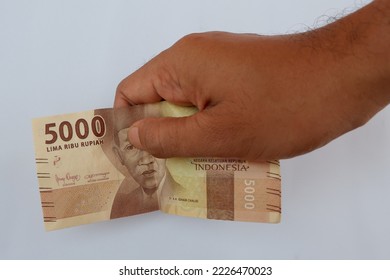 Man Right Hand Showing 5000 Indonesian Rupiah Notes