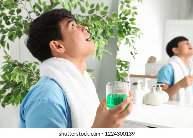 Man Rinsing Mouth With Mouthwash In Bathroom. Teeth Care