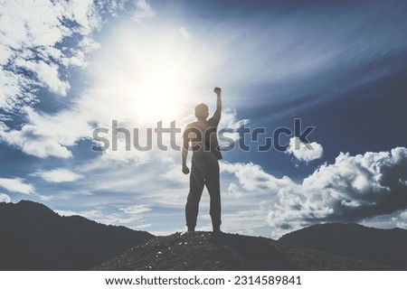 Man rise hand up to amazing blue sky feel never give up and freedom.