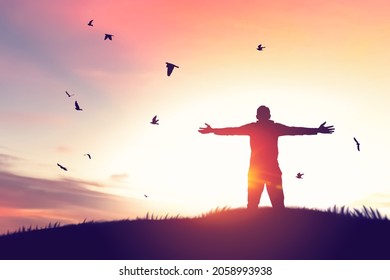 Man rising hands and birds flying on sunset sky at nature field abstract background. Freedom feel good and travel adventure concept. Vintage tone filter effect color style. - Shutterstock ID 2058993938