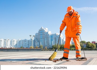 Man road sweeper caretaker cleaning city street with broom tool