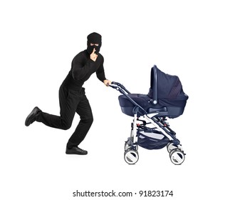 A Man In Robbery Mask Running And Pushing A Baby Stroller With Finger On The Lips Gesturing Silence Isolated On White Background