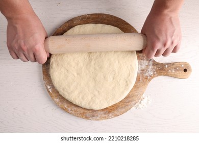 Man Rolling Dough With Wooden Pin At White Table, Top View