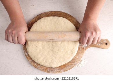 Man Rolling Dough With Wooden Pin At White Table, Top View