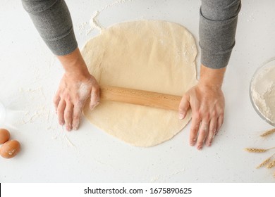 Man Rolling Out Dough In Kitchen