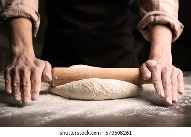 Man rolling out dough on kitchen table, close up - Powered by Shutterstock