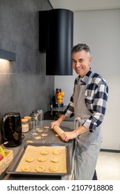 Man Rolling Out Raw Biscuits With Rolling Pin