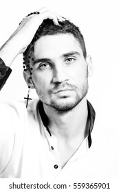 Man With Rosary With A Cross Holding His Head. Piercing Eyes. Close-up Portrait. High Key.