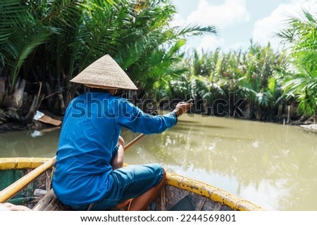 Man rowing a basket boat, along the coconut river forest, a unique Vietnamese at Cam thanh village. Landmark and popular for tourists attractions in Hoi An. Vietnam and Southeast Asia travel concepts