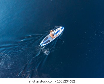 Man rowing oar on sup board blue sea water. Aerial top view paddleboard. - Powered by Shutterstock