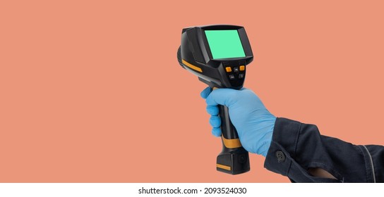 Man In Rubber Gloves Holds A Thermographic Camera. Device For Monitoring The Temperature Distribution Of The Surface Under Study. Thermal Imager In Hand. Infrared Thermography