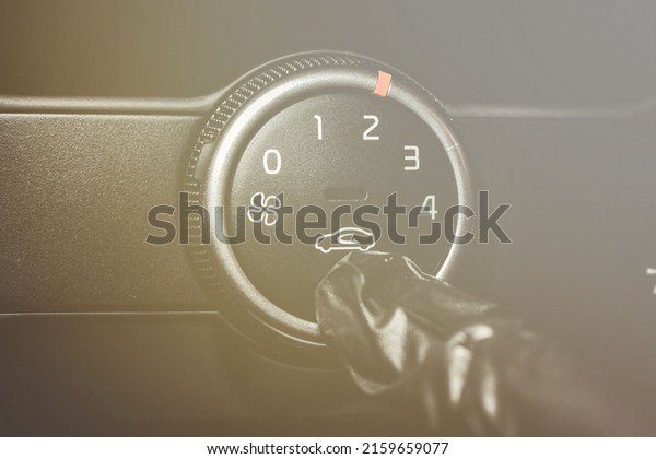 A man in rubber\
gloves turns on the air conditioner in the car. The driver turns on\
the car\'s climate control system. Travel by car. Close-up view with\
selective focus.
