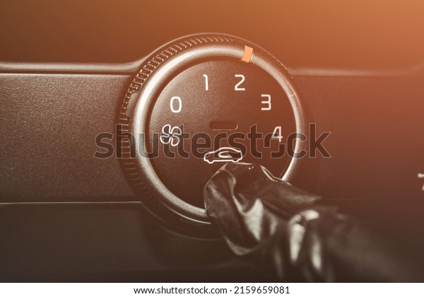 A man in rubber\
gloves turns on the air conditioner in the car. The driver turns on\
the car\'s climate control system. Travel by car. Close-up view with\
selective focus.