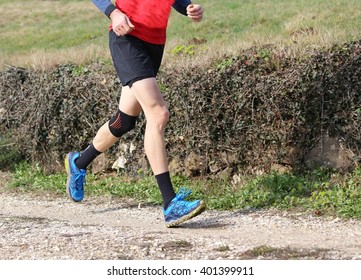 Man Runner During The Cross-country Race With His Knee Wrapped By A Knee Brace