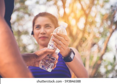 Man Runner Giving Bottle Of Water To The Friend In Front Of Her