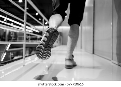 Man Runner Legs And Shoes In Action At Sport Shop. Shoot In Black And White Shot.