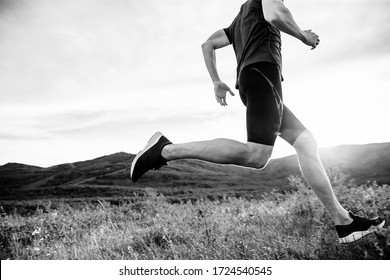 Man Runner Run On Mountain Trail In Rays Of Summer Sunset