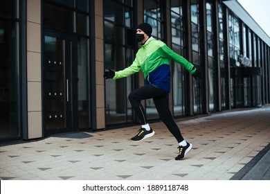 Man Runner Wearing Face Mask. Training During Covid-19 Pandemic. Winter Exercise To Stay Fit. Urban City Jogger. Smiling Man Fitness Workout. Active And Healthy Life In Quarantine 